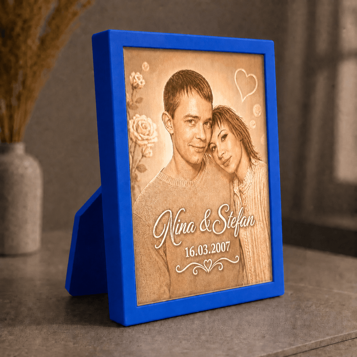 Personalisiertes 3D-Lichtbild Klassik mit Standrahmen in Blau und Wunschfoto von Nina und Stefan, dekorativ in warmer Wohnatmosphäre präsentiert.