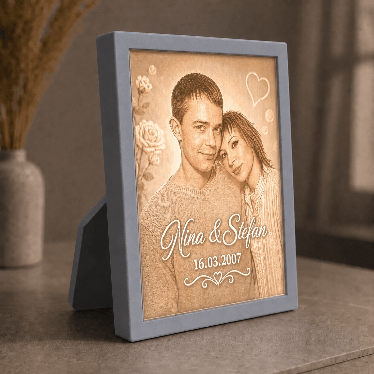 Personalisiertes 3D-Lichtbild Klassik mit Standrahmen in Grau und Wunschfoto von Nina und Stefan, dekorativ in warmer Wohnatmosphäre präsentiert.