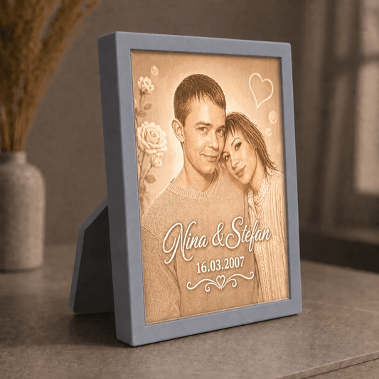 Personalisiertes 3D-Lichtbild Klassik mit Standrahmen in Grau und Wunschfoto von Nina und Stefan, dekorativ in warmer Wohnatmosphäre präsentiert.